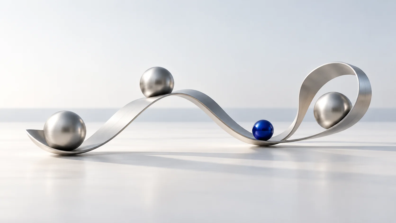 Silver spheres and a cobalt sphere on a flowing metal ribbon.